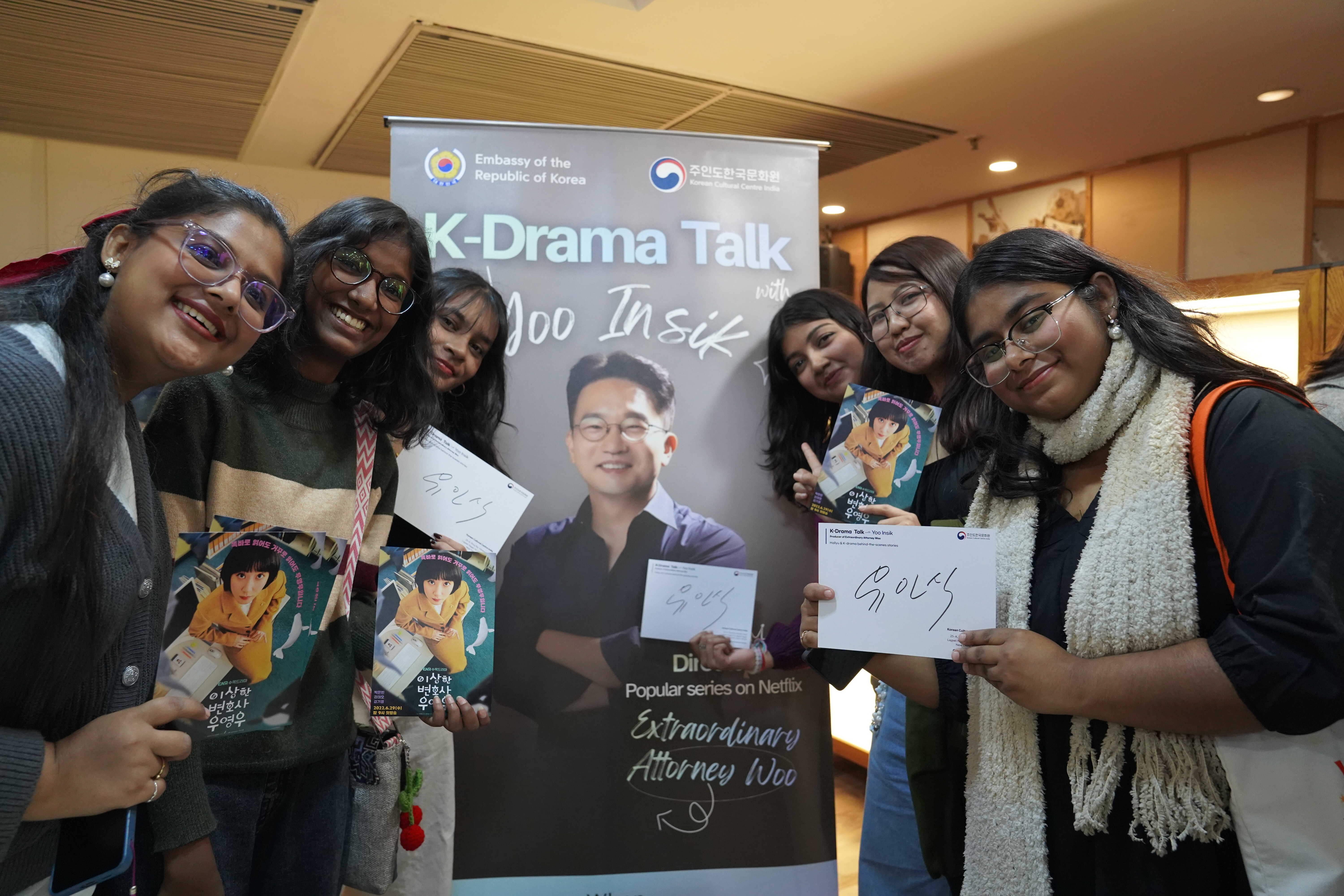 사인받은 기념 포스트카드를 들고 포즈를 취하는 참가자들