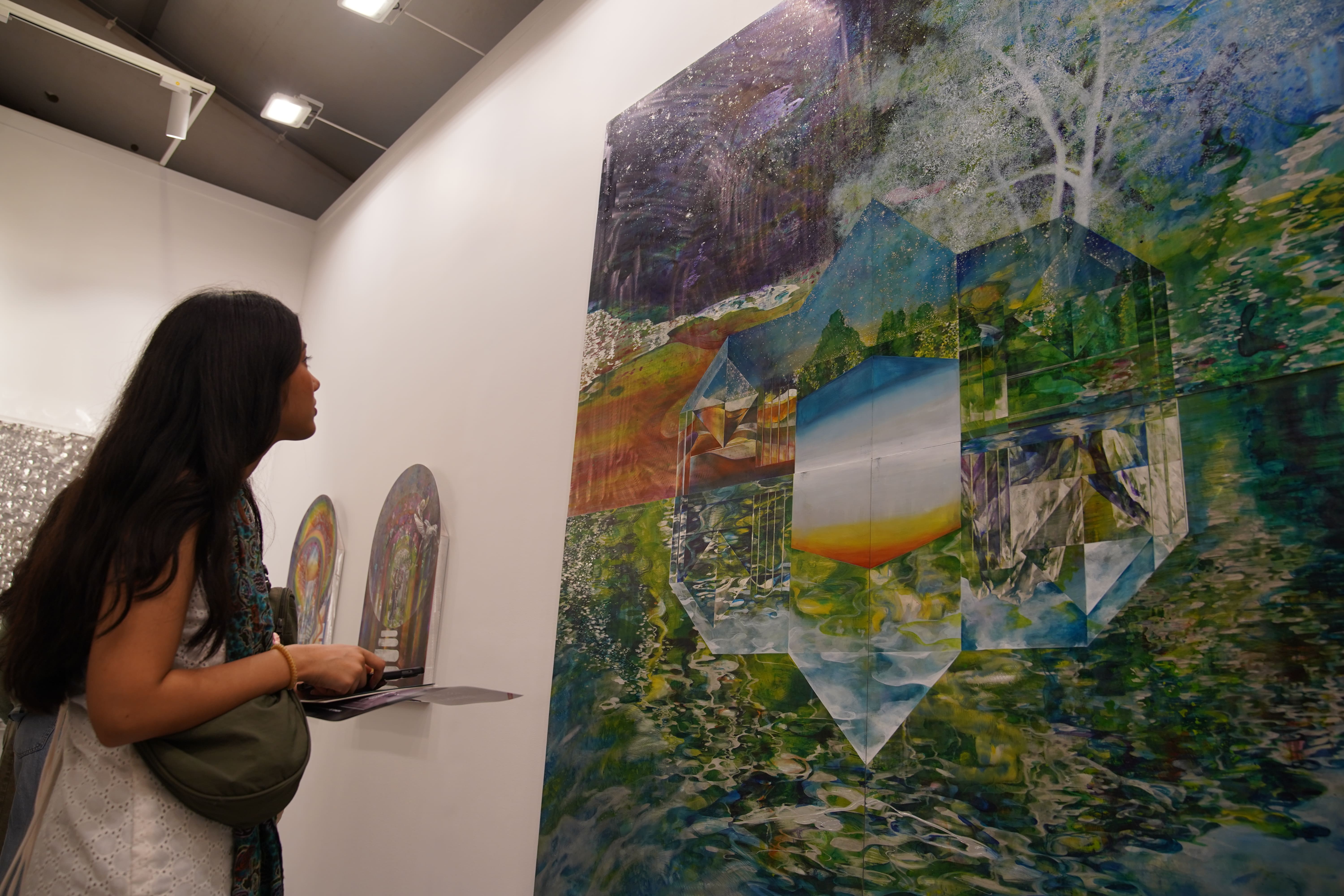 스테인레스를 긁어 다채로운 색상을 표현한 작품을 관람하는 관객